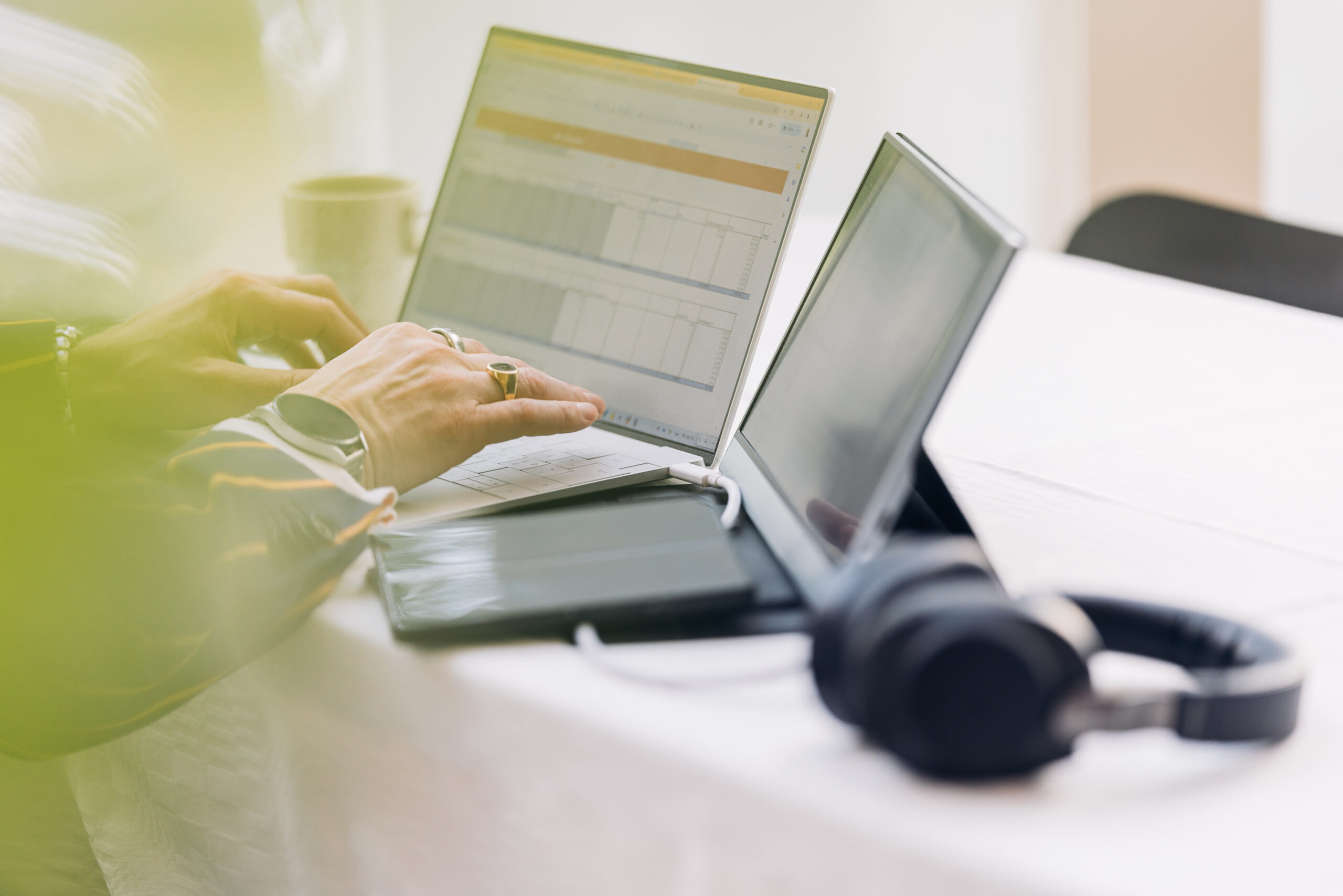 Man i kostym med sina datorer som arbetar i excel.